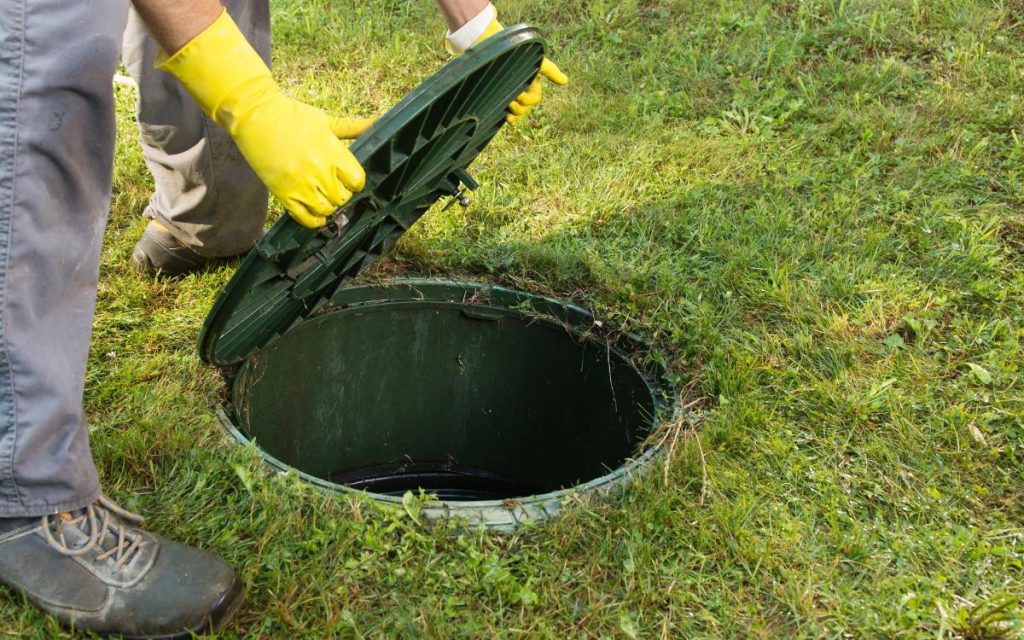 man opening septic tank cover